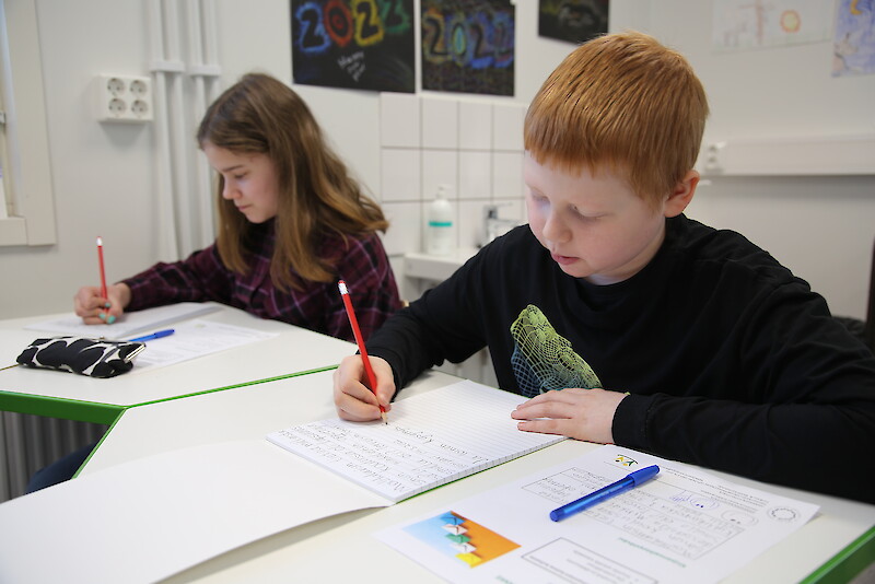 Tässä syntyy tervehdyksiä hämeenkyröläisille ikäihmisille. Kirjeitä kirjoittamassa Heinijärven koulun neljäsluokkalaiset Saaga Pylsy ja Tommi Järvenpää.