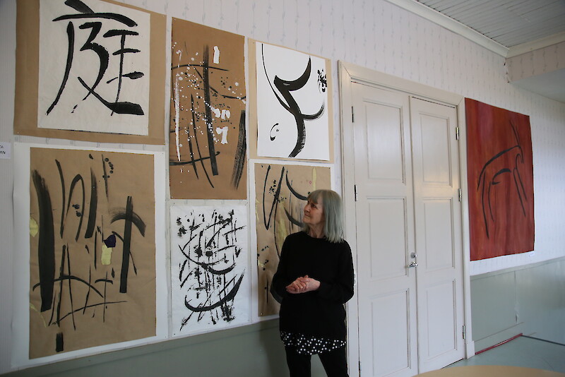 Minni Huusarin Omalla Tuvalla esillä olevaan näyttelyyn kuuluvat muun muassa etualan kokonaisuus Rakkaudesta kalligrafiaan ja taustalla loikkaava Peurapoika.
