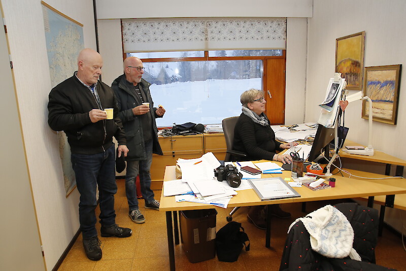 UutisOivan toimittaja Terhi Palonen näyttää joulukahveille poikenneille Hannu Taupilalle ja Pentti Mobergille, miten juttu laitetaan verkkosivulle.