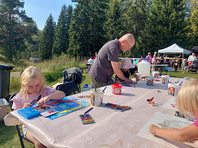 Armi Niiranen, 6, ja Viivi Soukko, 5, maalaavat keskittyneesti. Kuvataidepajan apuohjaaja Mikael Härkänen auttelee Viivi Soukkoa tämän työn valmistumisessa.