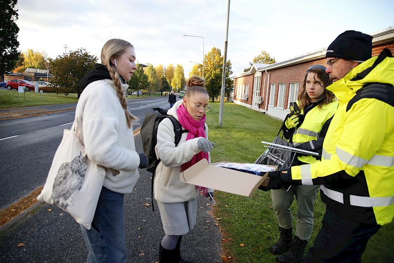 Ikatalla opiskelevat Ella Alenius ja Angelina Wivolin ilahtuivat heijastimista, joita olivat jakamassa Ikaalisten nuorisovaltuustosta Jero Lampila ja Liikenneturvan Marko Nieminen.