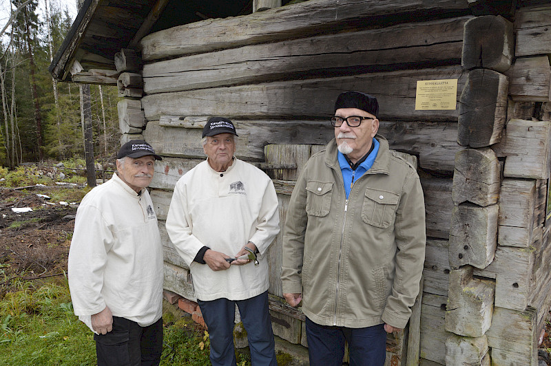 Savusaunaklubin edustajat Seppo Leskinen ja Pentti Hakala palkitsivat Eero Pylsyn historiallisen savusaunan kunnossapidosta.