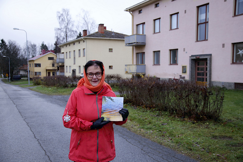 Runoilija kotikadulla. Merja Ahlgrén on Kyröskosken kasvatti, joka on asunut syntymäkylässään 15 osoitteessa. Muun muassa taustalla näkyvissä keltaisissa taloissa Koulukadun varrella.