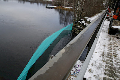 Salmen suulle asetettu suojaus kerää sillan purkutyössä mahdollisesti veteen putoavan aineksen talteen.