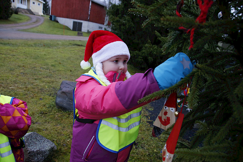 Esikoululainen Alisa Viikeri ripustaa tonttuaan, jonka maalaaminen oli kuulemma helppoa.