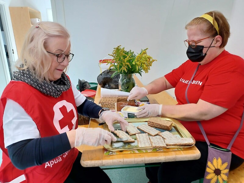 SPR:n vapaaehtoiset Paula Saarilahti ja Leena Palmu-Aalto voitelemassa leipiä viime lauantaisella yhteisöluonaalla.