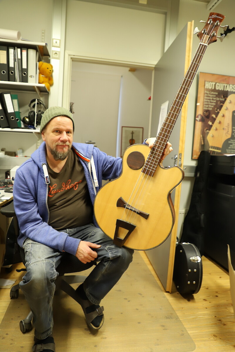 Kitaranrakennuksen opettaja Anssi Nuutinen esittelee kollegansa Tero Siromaan valmistamaa bassoa, jossa runko ja kaula ovat mahonkia, otelauta ruusupuuta ja kansi kuusta. Ruusupuu on erityisen kova puulaji, joka kestää kulutusta. Mahonki on puolestaan kevyttä, joten se tekee soittimesta sopivan painoisen. Kuusessa painon ja jäykkyyden suhde on erinomainen, joten se on paras soittimen kansipuuksi.